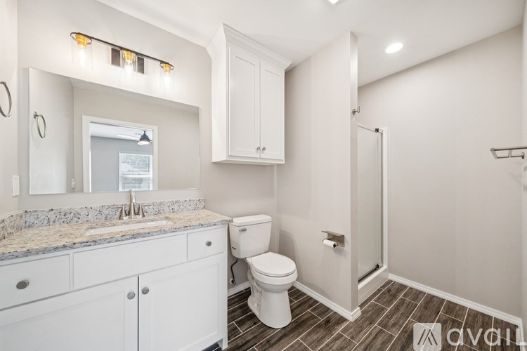 A bathroom with a toilet, sink, and shower.