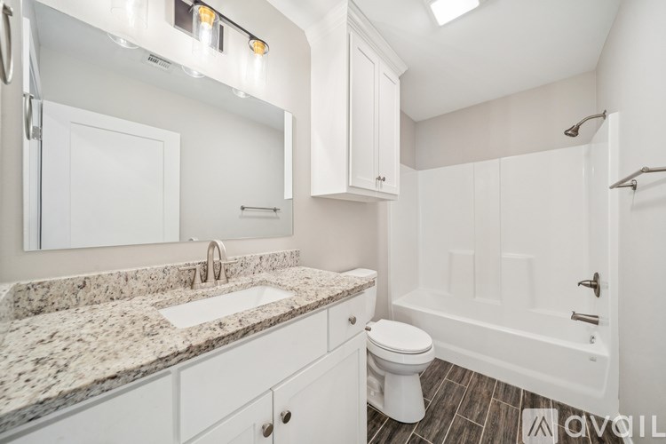 A bathroom with a sink, toilet, and bathtub.