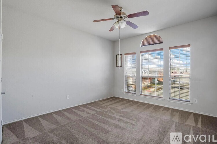 A room with a ceiling fan and a carpeted floor.