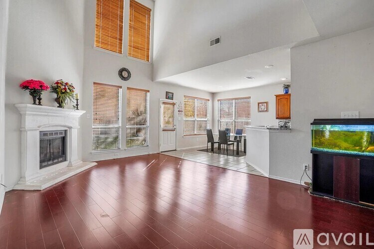 A living room with a fireplace, chairs, and a television.
