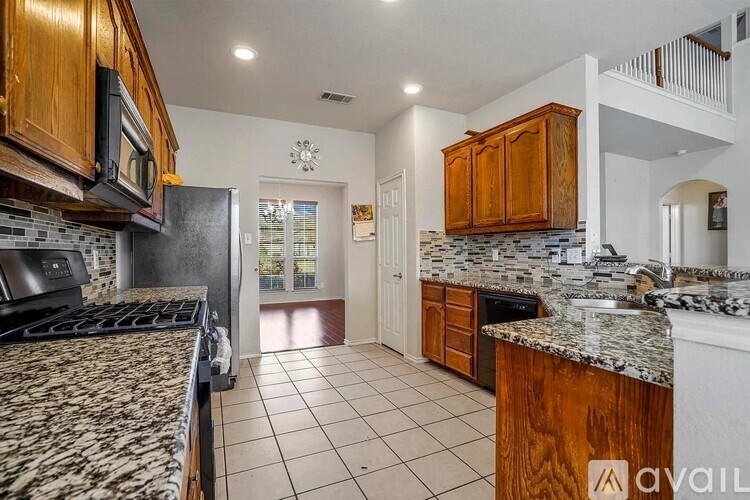 A kitchen with granite countertops and wooden cabinets.