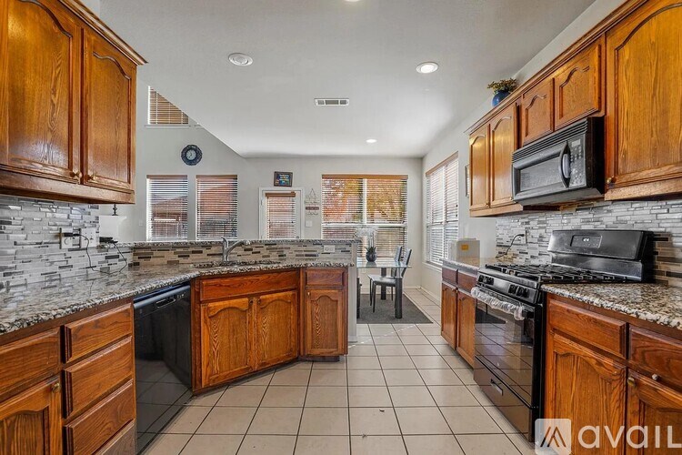 A kitchen with wooden cabinets and a stone backsplash.