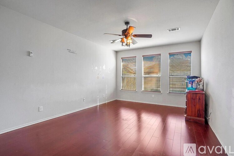 A room with a ceiling fan and a wooden floor.