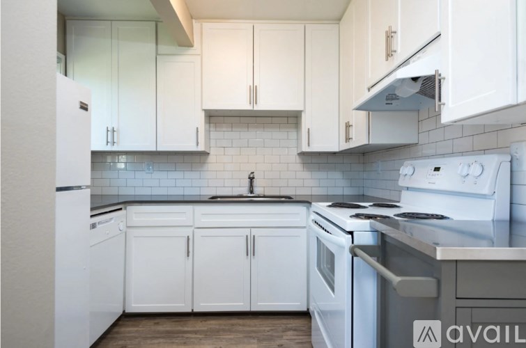 A kitchen with white appliances and cabinets.