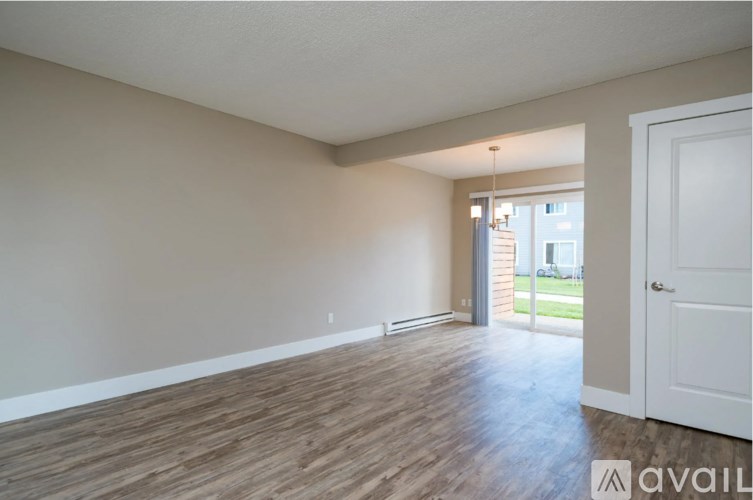 A room with wooden flooring and a white door.