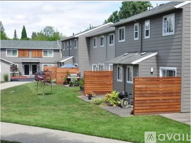 A row of houses with a lawn in front of them.