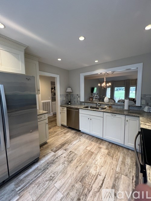 A kitchen with a refrigerator, cabinets, and a countertop.