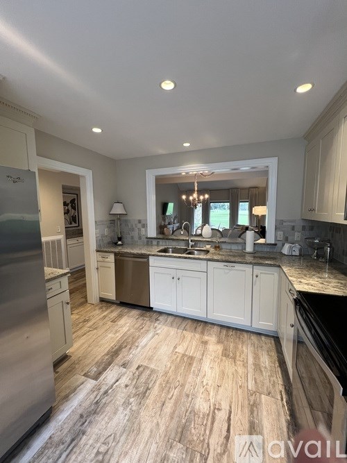 A kitchen with a refrigerator, sink, and cabinets.