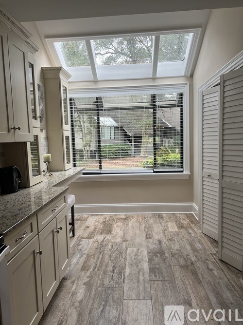 A kitchen with a skylight above the window.