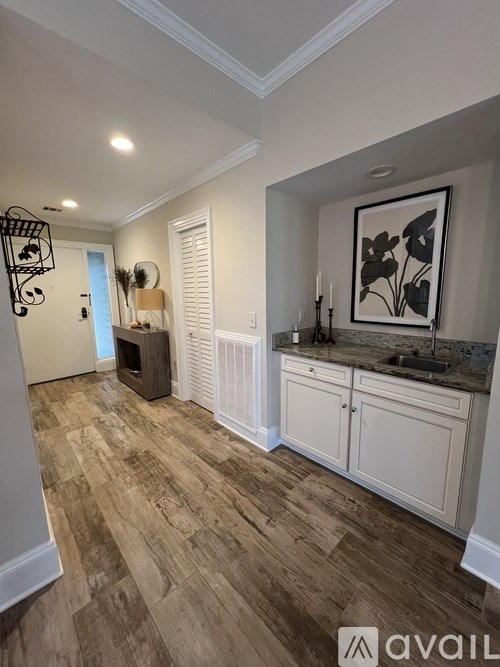 A room with wooden flooring and a framed picture on the wall.