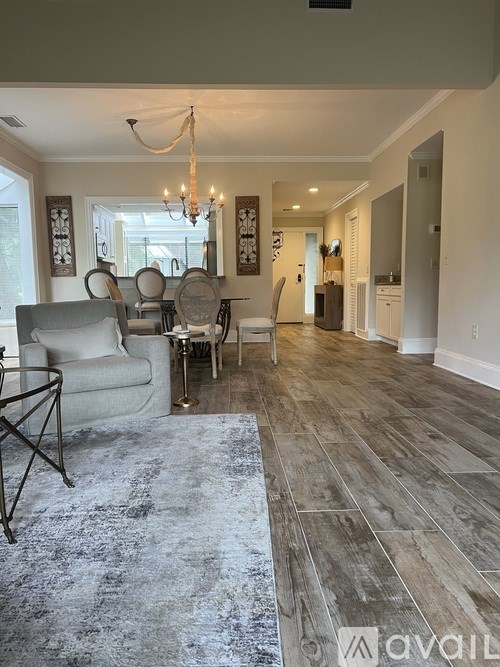 A living room with a grey sofa and a wooden floor.
