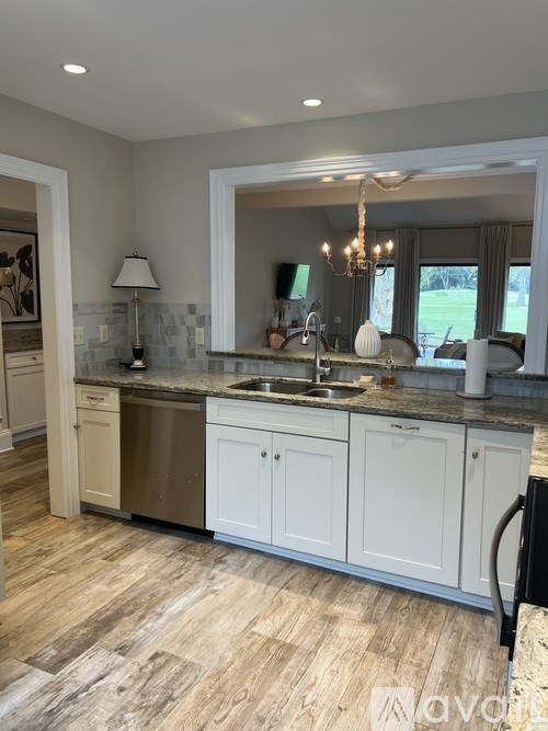 A kitchen with a sink, a window, and a chandelier.