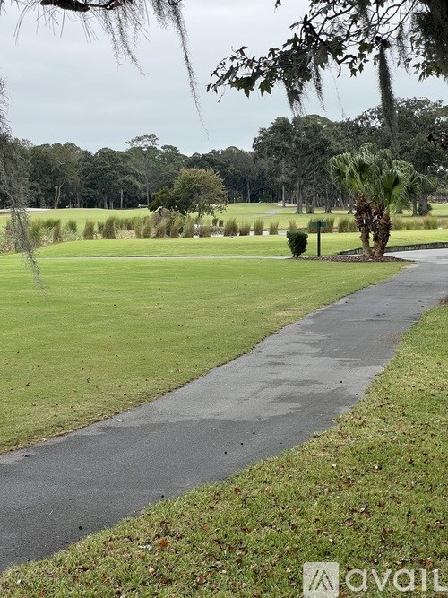A wet pathway leads through a grassy area.