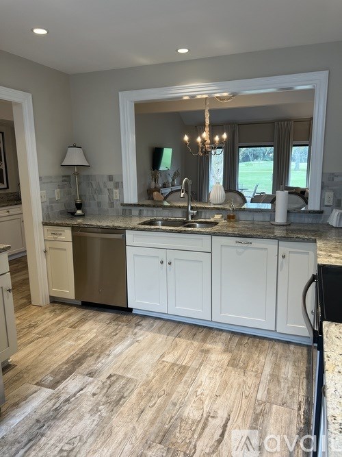 A kitchen with a sink, cabinets, and a window.