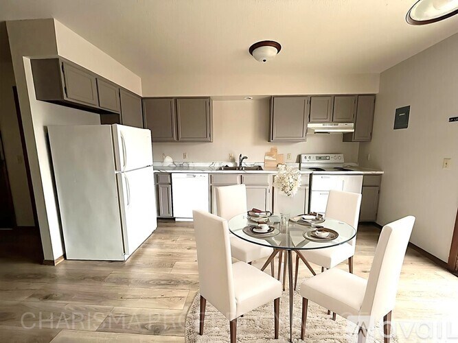 A kitchen with a dining table and chairs.