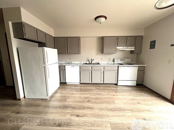 A kitchen with white appliances and wooden floors.