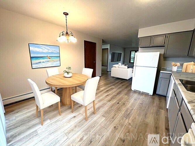 A kitchen with a dining table and chairs is shown.