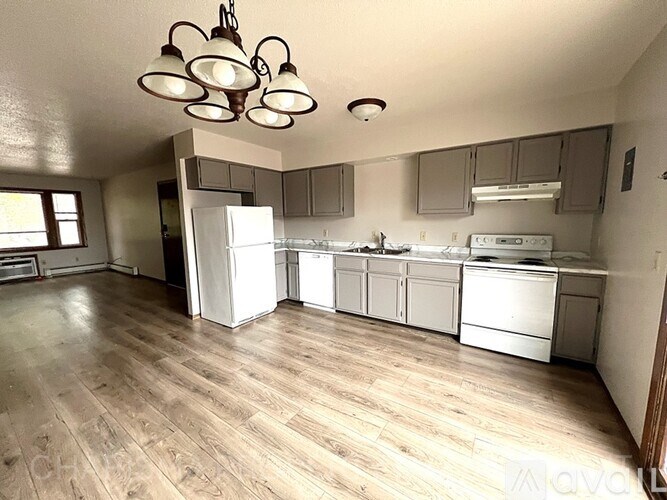 A kitchen with wooden floors and white appliances.