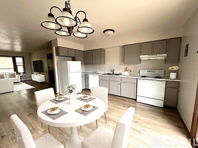 A modern kitchen with a dining table set for four.
