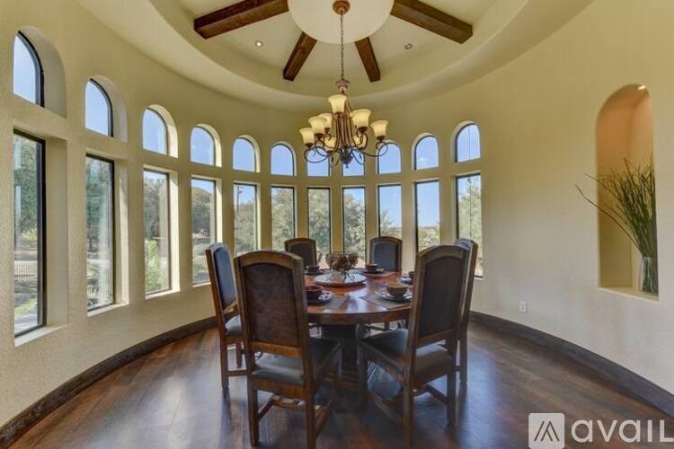 A dining room with a round table and chairs.