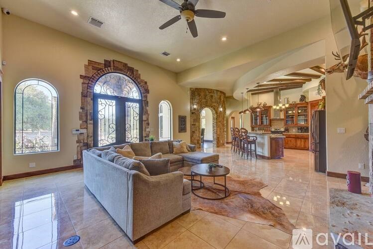 A living room with a couch, a coffee table, and a ceiling fan.