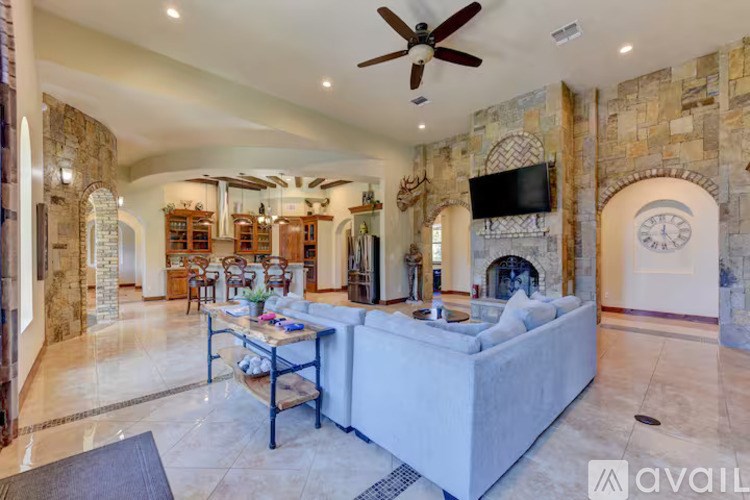 A spacious living room with a large couch and a fireplace.