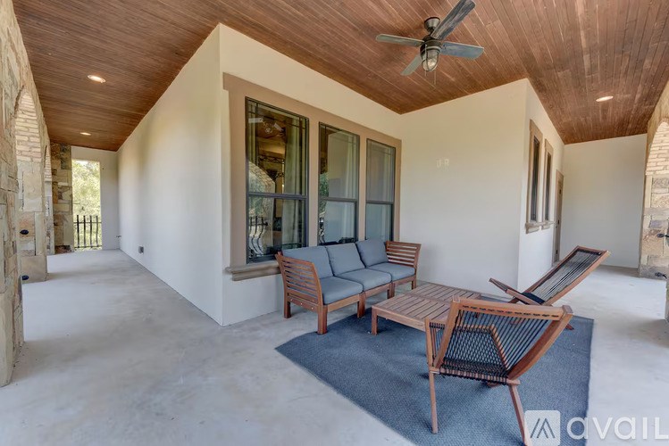 A wooden table and chairs are set up on a rug in a room with a ceiling fan.