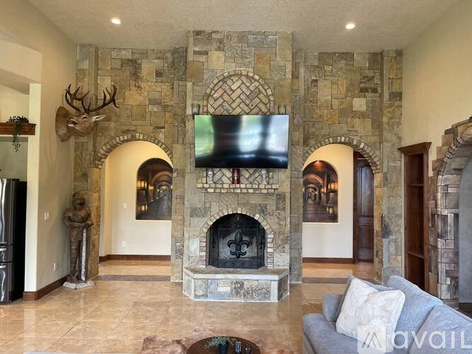 A stone fireplace with a flat screen TV above it.