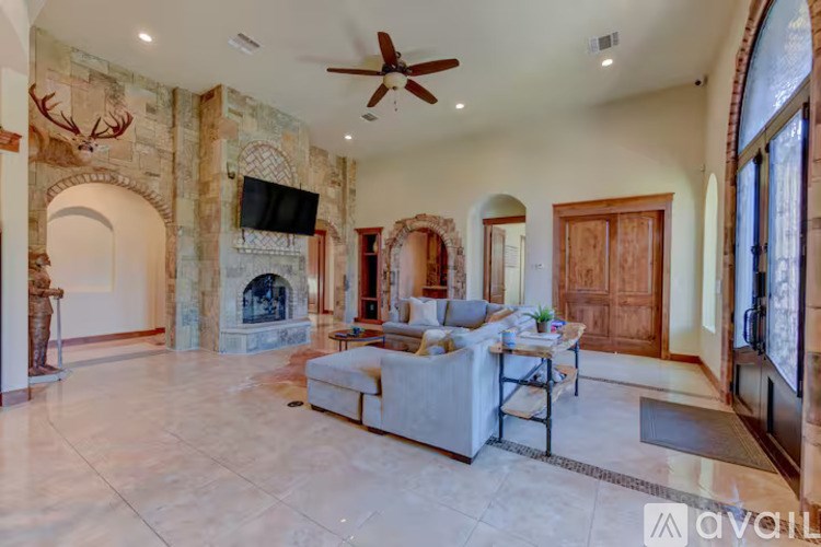 A living room with a stone wall and a fireplace.