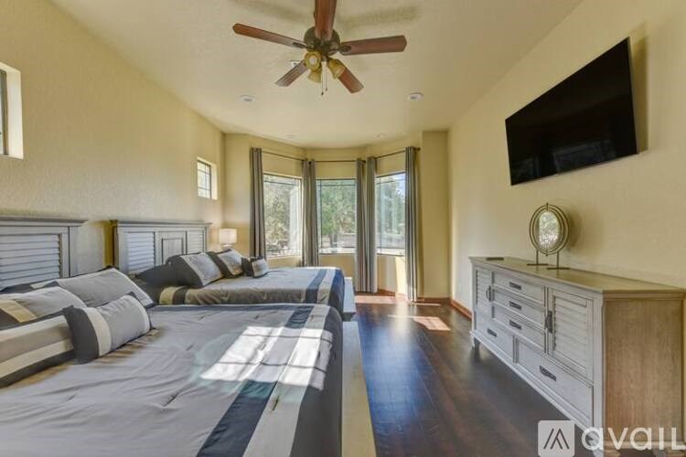 A bedroom with a large bed and a flat screen TV mounted on the wall.