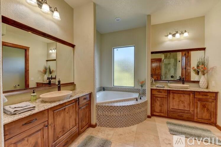 A bathroom with a tub, sink, and mirror.