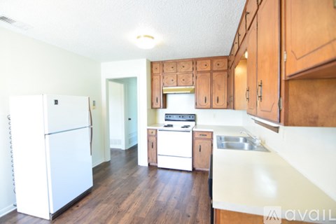 A kitchen with wooden cabinets and a white fridge.