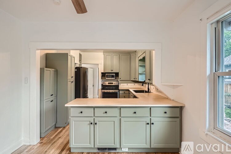 A kitchen with a white countertop and cabinets.