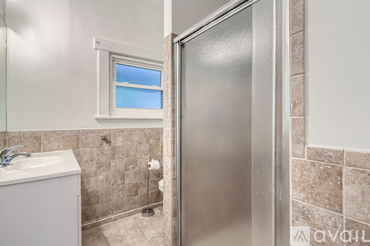 A bathroom with a walk-in shower and a window.