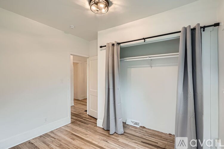 A room with a sliding door and grey curtains.