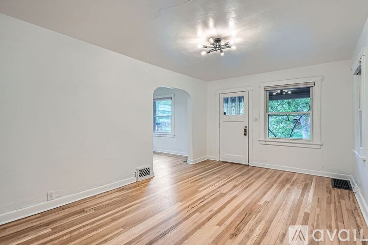 A room with wooden flooring and a ceiling fan.