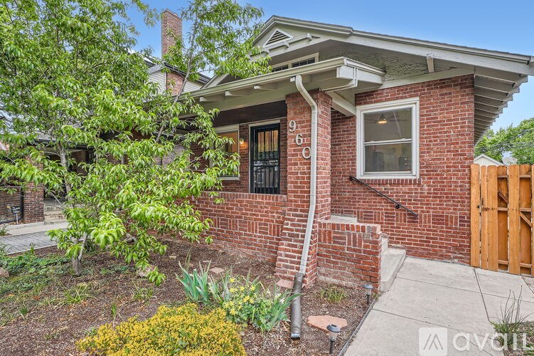 A house with a red brick exterior and a wooden fence.