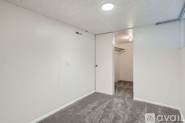 A room with a carpeted floor and a doorway leading to another room.