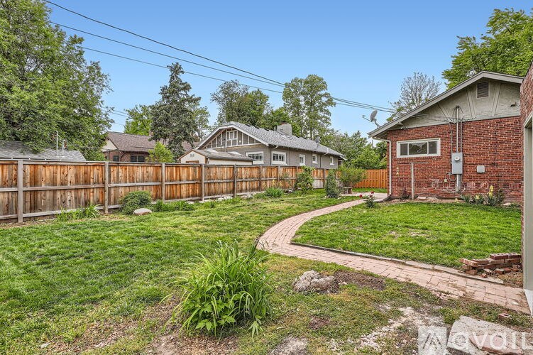 A backyard with a wooden fence and a small house.