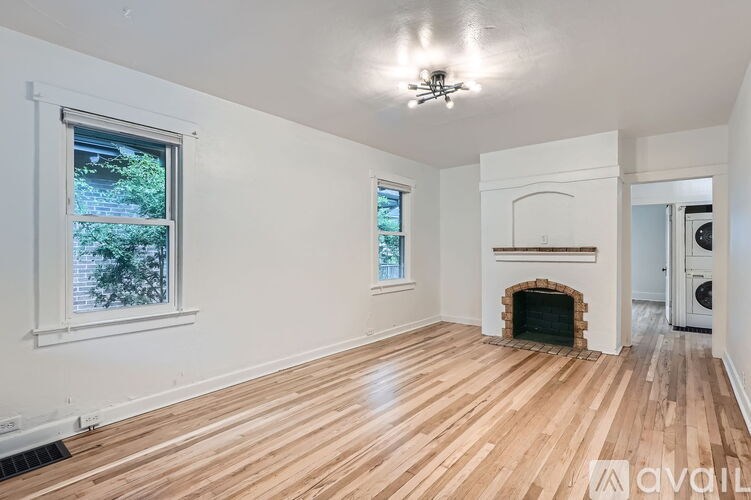 A room with wooden floors and a fireplace is available for rent.