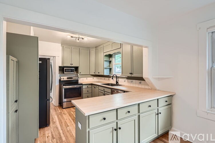 A kitchen with a wooden countertop and grey cabinets.