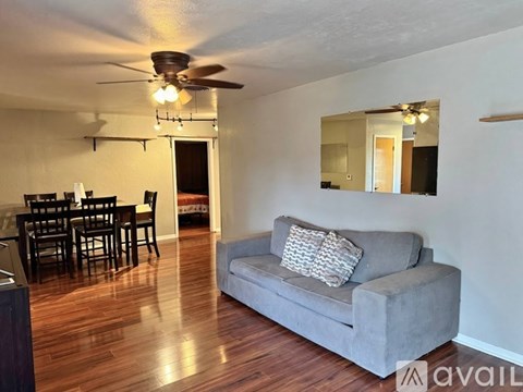 A living room with a grey couch and a dining table.