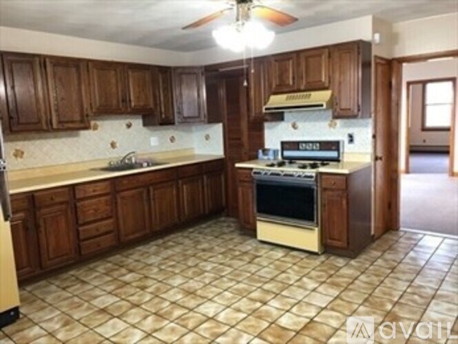 A kitchen with brown cabinets and a tiled floor.