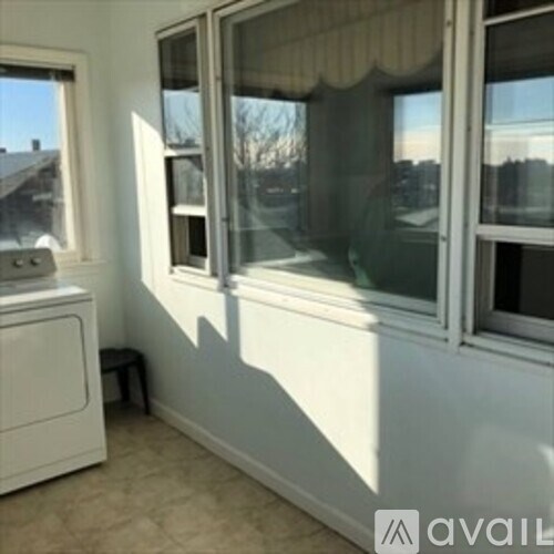 A white cabinet sits next to a window in a room.