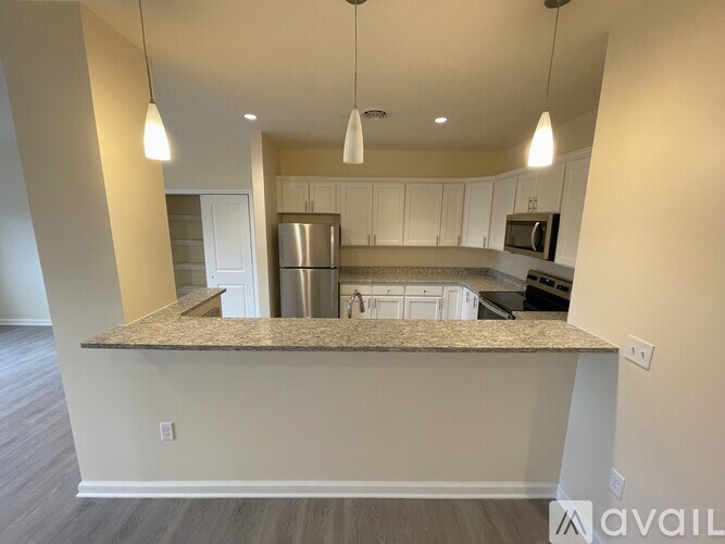 A kitchen with a granite countertop and stainless steel appliances.