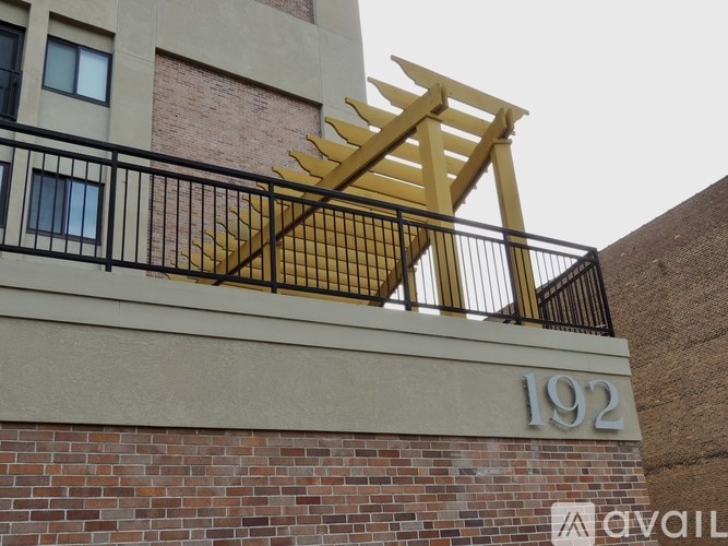 A building with a balcony railing and a sign that says 192.