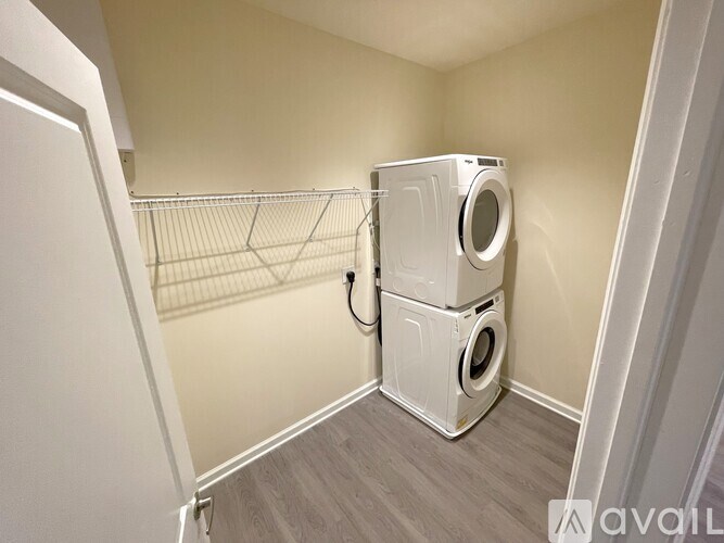 A small laundry room with a washer and dryer stacked on top of each other.