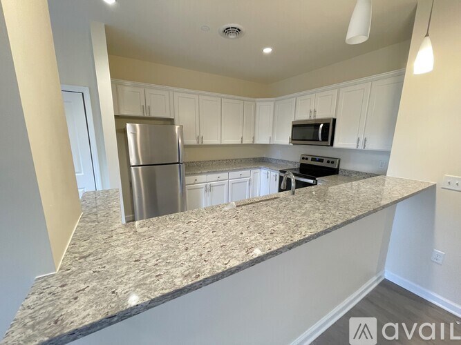 A kitchen with granite countertops and stainless steel appliances is available for rent.