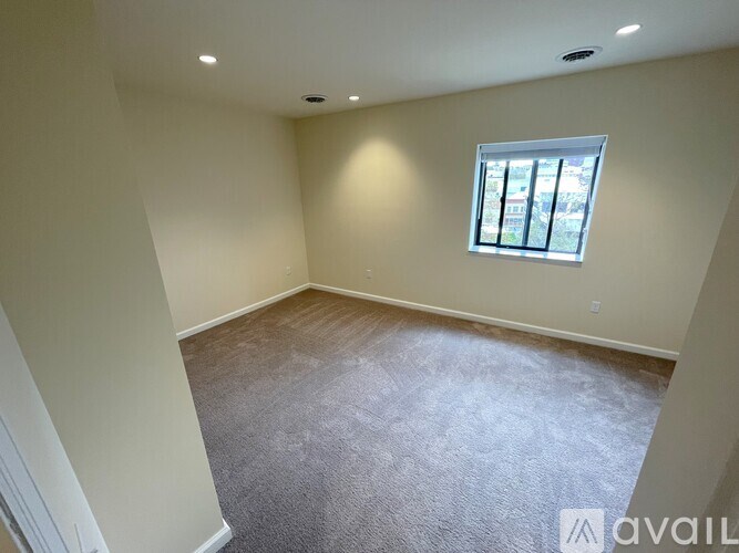 A room with a carpeted floor and a window.