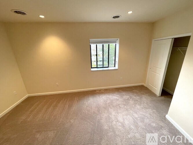 A room with a window and a door is available for rent.